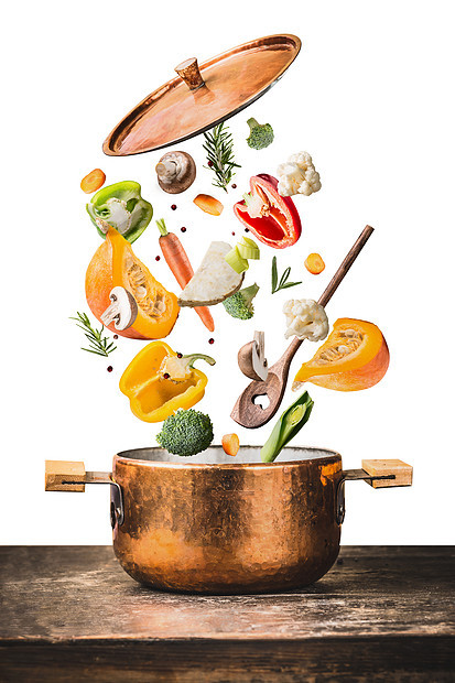 健康的素食饮食烹饪与各种飞斩蔬菜成分,烹饪锅勺子木制桌子上,隔离白色背景,正视图清洁食品的图片
