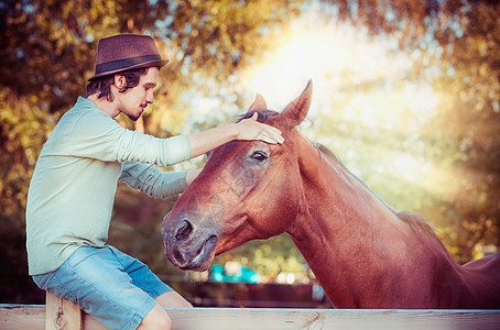 人与马交流的感伤场景个闭着眼睛的轻人抱着匹漂亮的红马的头图片