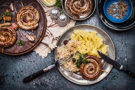 乡村食品与烤香肠土豆泥酸甘蓝沙拉,盘子与餐具,顶部视图德国食品图片