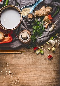 素食亚洲美食配料与切碎蔬菜,椰奶,种子,香料筷子乡村木制背景,顶部视图中国泰国菜烹饪背景图片