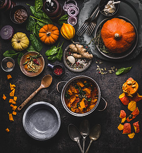 秋冬烹饪吃南瓜菜素食炖锅与勺子蔬菜配料黑暗的厨房桌子背景,顶部视图健康的季节食物图片