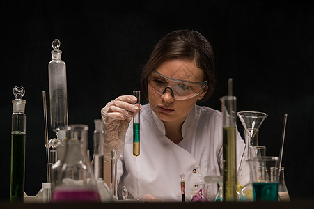 化学实验室场景吸引力的轻博士学生科学家用液体观察管子图片
