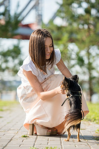 快乐女孩城市公园她的狗散步的肖像图片
