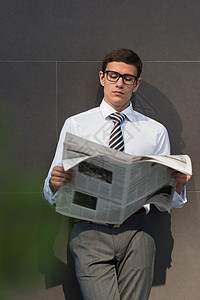 英俊的商人经理,现代办公建筑前,阅读报纸图片