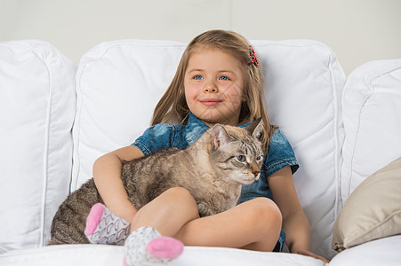 可爱的小女孩抱着塔比猫,看着远方图片
