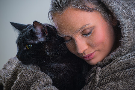 抱着大黑猫的轻善良女人的冬天肖像霜雪他们身上图片