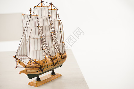 白色背景下白色桌子上的木船玩具模型图片