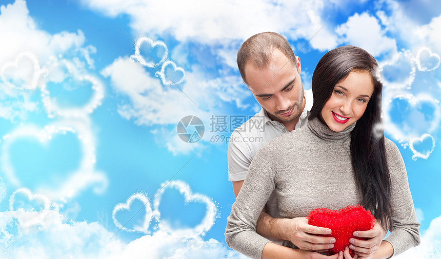 美丽的轻夫妇拥抱并看着相机站浪漫的背景,情人节风格