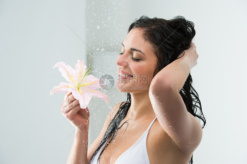 女人洗自己的时候,沐浴着快乐的微笑,百合花水溅美丽的白种人女模特酒店淋浴小屋度假图片