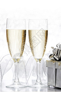 杯香槟银色的礼物闪光的背景上图片