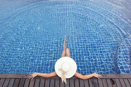 戴大帽子的女人游泳池里放松女人戴着大帽子游泳池里图片