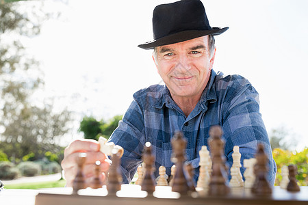 老人坐户外下棋思考国际象棋策略高清图片