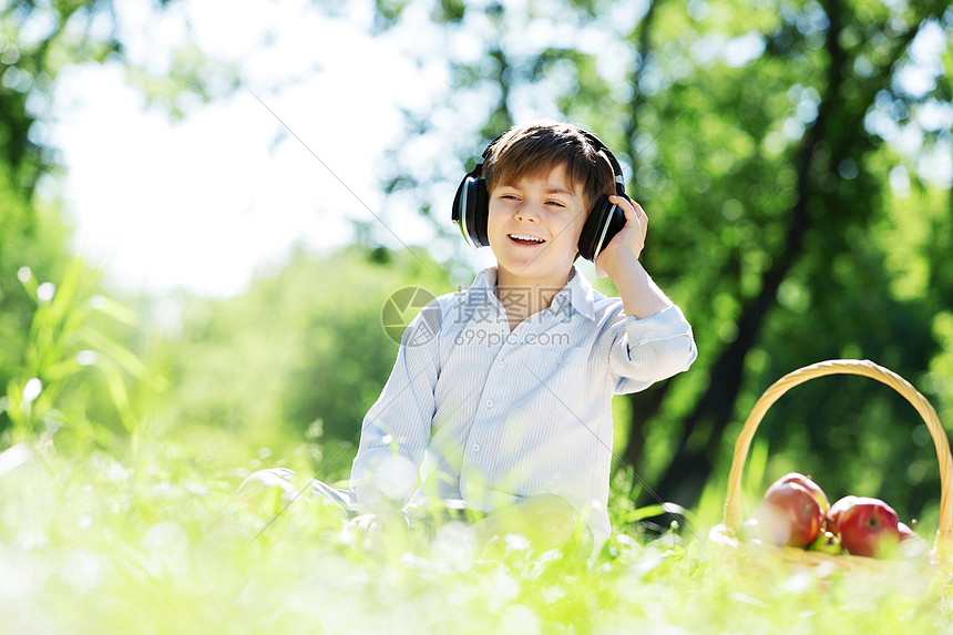 夏天公园里的小快乐男孩戴着耳机大自然的声音图片