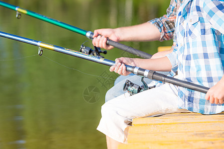 个着鱼竿的男孩的手的特写个男孩的手的特写,他着根钓鱼竿码头上钓鱼图片