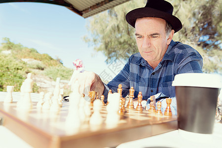 老人坐户外下棋思考国际象棋策略图片