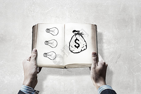 如何赚钱男手中打开了本书,书页上金融想法图片