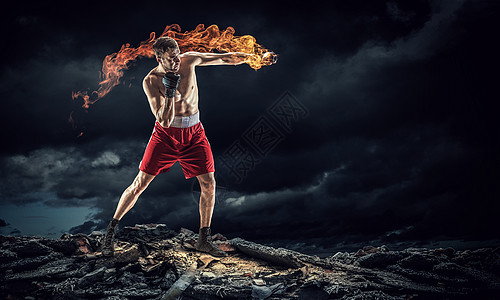 火焰拳头背景箱式战斗机户外训练黑暗背景下的强壮拳击手展示了力量耐力背景