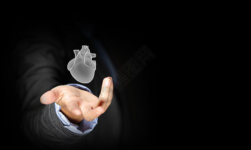 人类的心脏把人的心放手心里的商人的特写图片