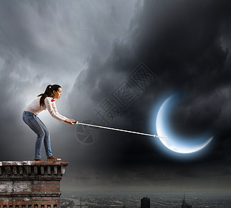 女人抓月亮轻的女人穿着休闲的绳子抓月亮背景图片