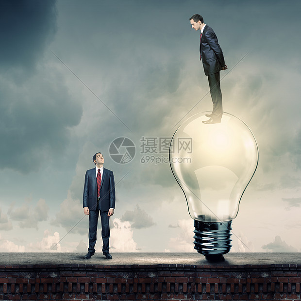 业务进展商人站灯泡上低头看着同事