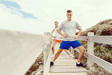 跑步者轻夫妇海滩上锻炼站稳跑步者轻夫妇海滩上运动高清图片