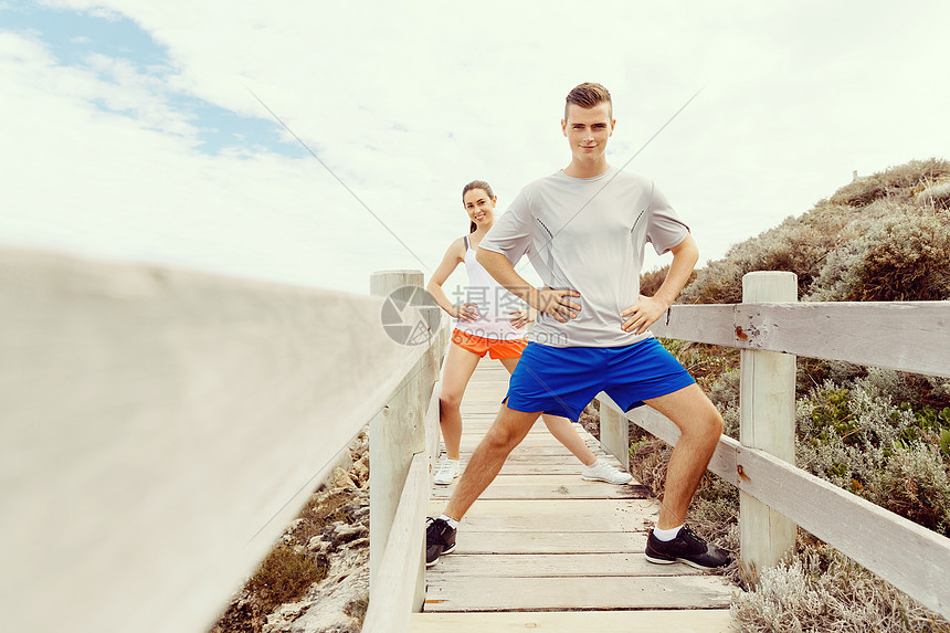 跑步者轻夫妇海滩上锻炼站稳跑步者轻夫妇海滩上运动图片