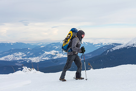 徒步山冬天穿着雪鞋的徒步旅行者背景
