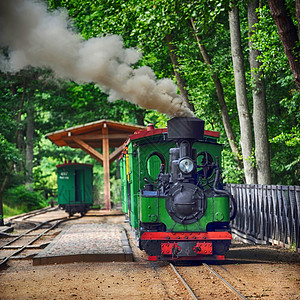 小绿色旧蒸汽机车骑铁轨上图片