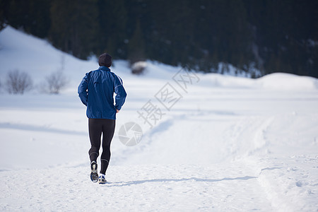 轻人森林里雪地上慢跑,阳光明媚的冬日英俊的运动阿特尔男人跑步图片