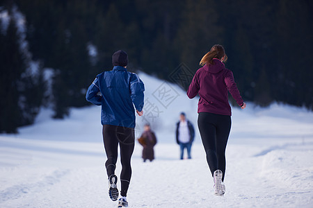 健康的轻夫妇森林里的雪地上慢跑运动员阳光明媚的冬日跑步图片