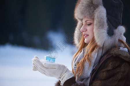 快乐的轻红发女孩手中礼物雪诞节冬天购物图片