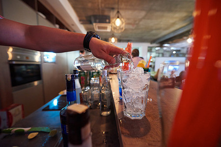 专业酒吧服务员准备新鲜的鸡尾酒饮料,代表夜生活聚会的图片