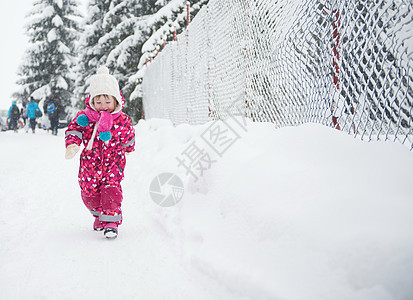 快乐微笑的小女孩户外的肖像,下雪的冬天新鲜的雪上玩图片