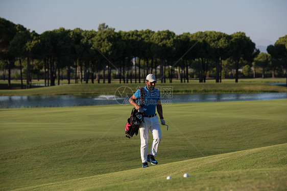 英俊的中东高尔夫球手背着包,走高尔夫球场的下个洞图片