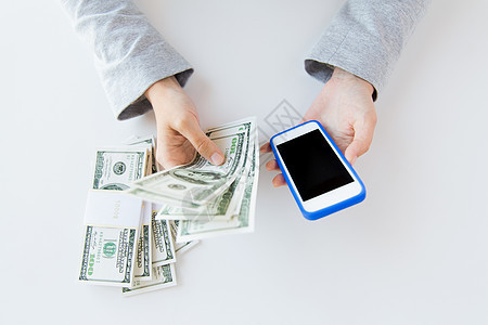 商业金融储蓄技术人的用智能手机美元的钱接近女人的手图片