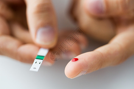 药物,糖尿病,血糖,保健人的密切男手指与血滴测试条纹图片