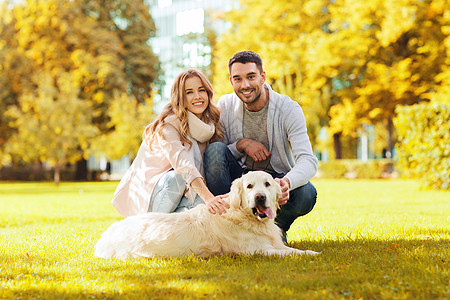 家庭,宠物,家畜,季节人的快乐的夫妇与拉布拉多猎犬秋季城市公园散步图片