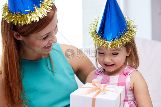 假期,生日家庭,童人的快乐的母亲小女孩戴着派帽,家里礼品盒图片