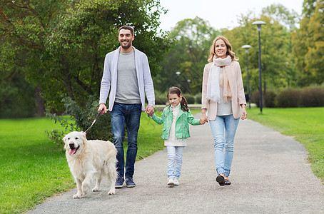 家庭,宠物,家畜人的快乐的家庭与拉布拉多猎犬夏季公园散步图片