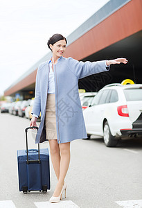旅行,商务旅行,人,手势旅游微笑的轻女人带着旅行袋机场航站楼火车站接出租车图片