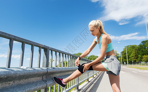 健身,运动,锻炼健康的生活方式轻妇女受伤的腿紧固膝盖支撑支架户外背景图片