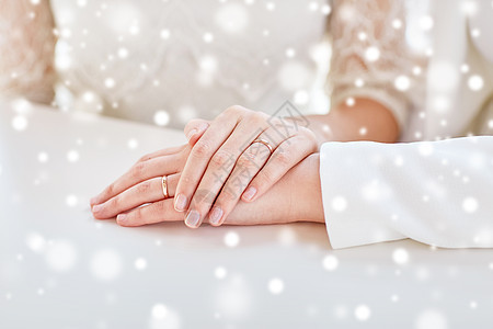 人,同婚姻爱情亲密的女夫妇的手与结婚戒指超过雪的效果图片
