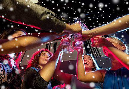 喝香槟新派,假期,庆祝,夜生活人们的微笑的朋友带着杯含酒精的香槟俱乐部雪的效果背景