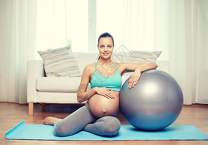 怀孕,运动,健身,人健康的生活方式快乐的孕妇家里用健身球锻炼图片