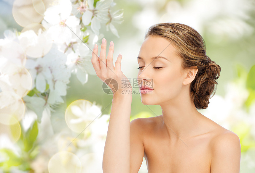 美丽,香气,人身体护理的轻的女人她的手的手腕闻香水与樱花绿色的自然背景图片