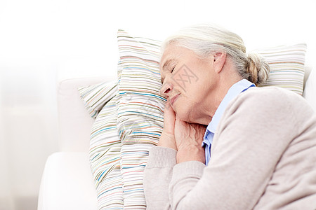 龄,放松人的快乐的老妇女睡枕头家里图片