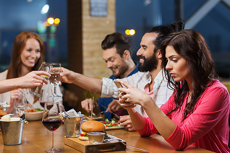 休闲,技术,网络成瘾,生活方式人的女人与智能手机朋友餐厅图片