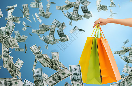 人,消费主义,金融销售特写女手购物袋蓝色背景金钱雨图片