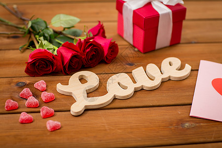浪漫,情人节假期的字爱,礼品盒,红玫瑰贺卡与心形糖果木材上图片