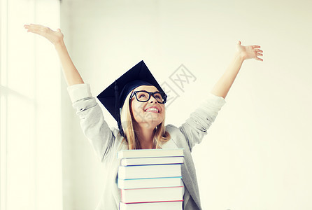 带着叠书的毕业帽里的快乐学生毕业帽里的快乐学生图片